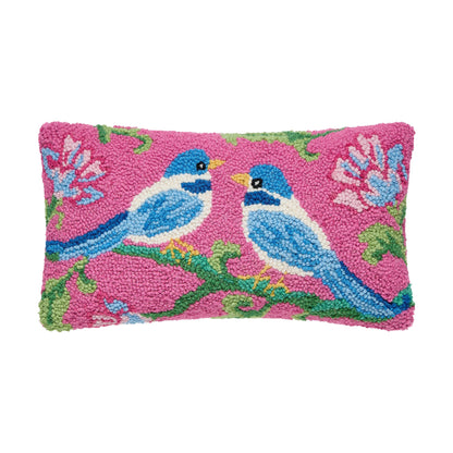 Rectangular pink wool pillow with two blue birds on green branches and pink and blue flowers, textured hooked design, soft velvet backing. Available sizes: 12″x22″.
