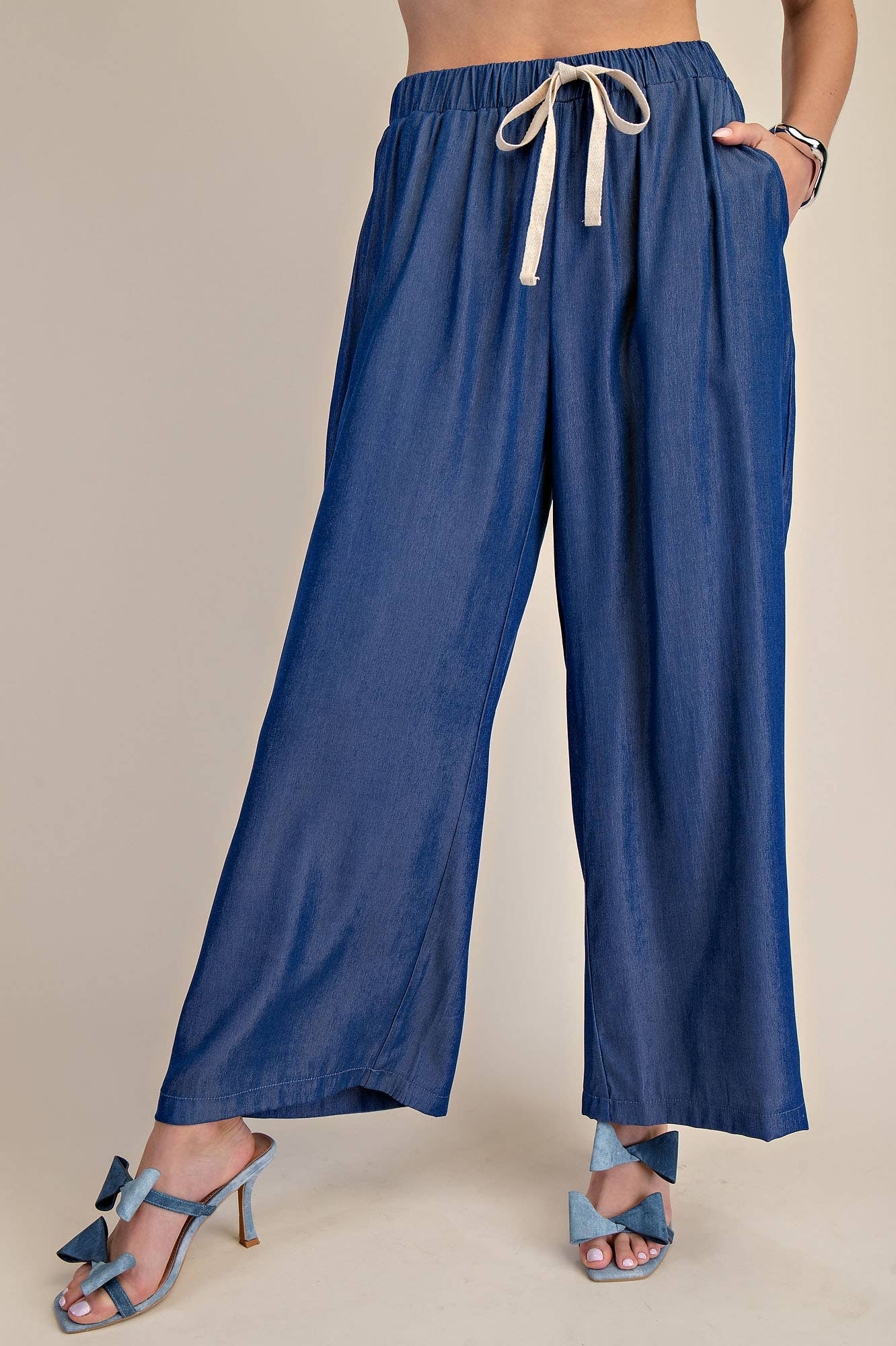 Indigo elastic band drawstring wide pants with beige tie; available in sizes XS-XL.