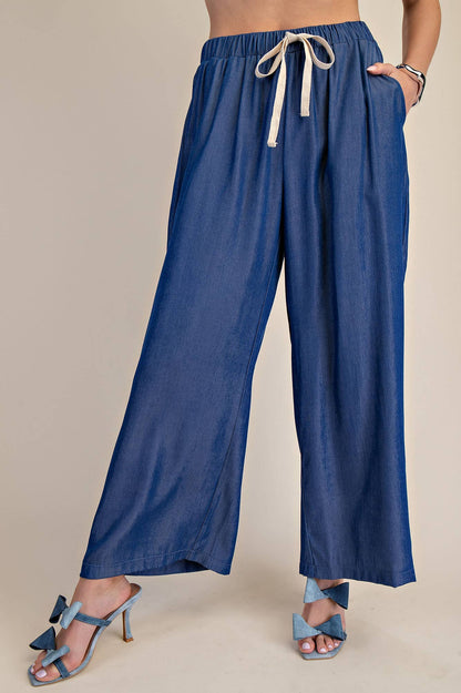 Indigo elastic band drawstring wide pants with beige tie; available in sizes XS-XL.