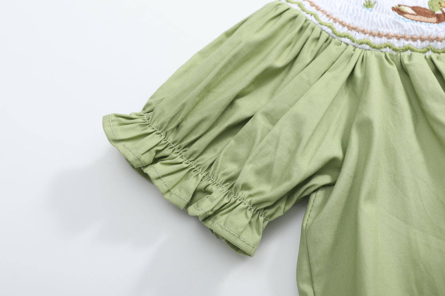 Green puff sleeve with gathered ruffle detail and partial embroidery on the Pistachio Green Mallard Duck Smocked Bishop Dress, available in size 3T.