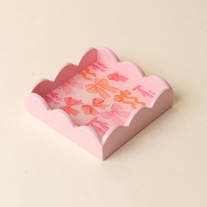 Scalloped beige trinket tray with pink interior, decorated with pink and orange bows. Sizes available.