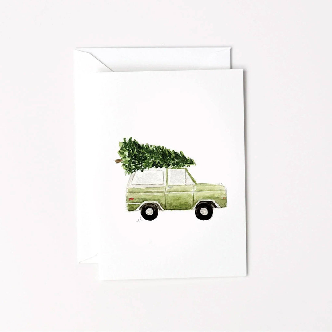 Watercolor illustration of a green vintage truck with a Christmas tree on its roof, mini enclosure notecard.