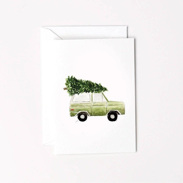 Watercolor illustration of a green vintage truck with a Christmas tree on its roof, mini enclosure notecard.