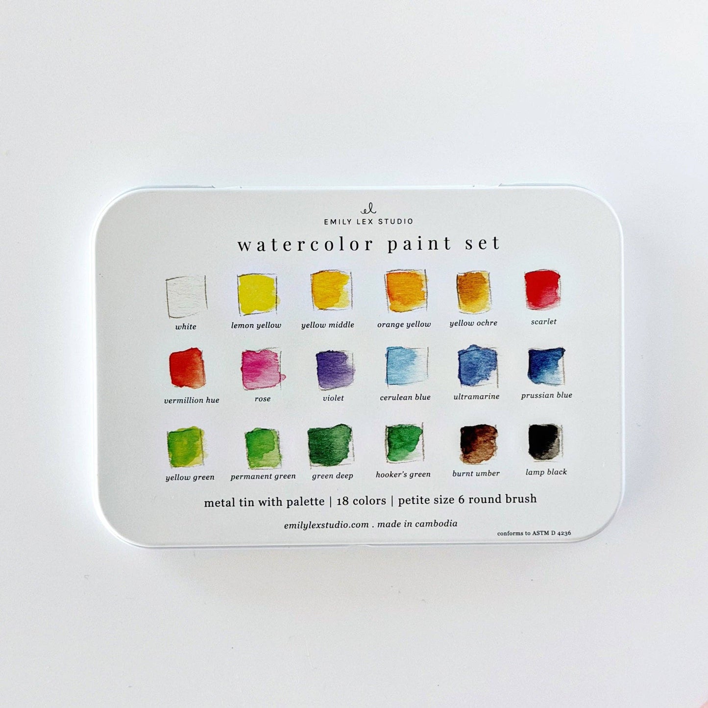 Watercolor paint set with 18 colors and a brush in a white metal tin labeled “watercolor paint set.” Each swatch is marked with its color name. Size: 18 colors.