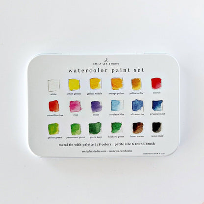 Watercolor paint set with 18 colors and a brush in a white metal tin labeled “watercolor paint set.” Each swatch is marked with its color name. Size: 18 colors.