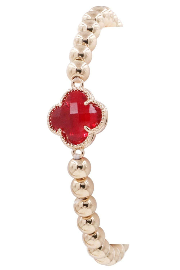 Gold bracelet with central red crystal clover charm in gold frame, gold beading accents. Available sizes: S, M, L.