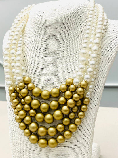 The CHIC - 5-Strand Pearl Necklace (white/matte gold) NK891 has three strands of high luster white pearls and five rows of large matte gold beads in a bold, layered design. Available sizes: not specified.