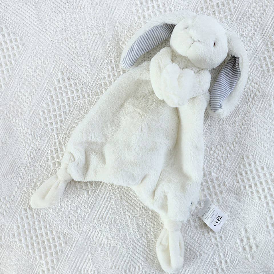 White lovey bunny with looped hands holding onto the blanket. Ears have striped fabric on inside and bunny has knots at the corners of the blanket.