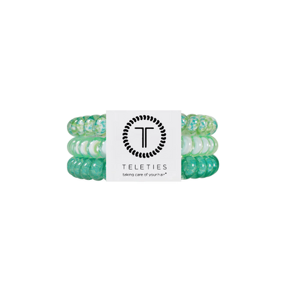 Three green and white TELETIES hair ties, secured by a branded label. Available in small, medium, and large sizes.