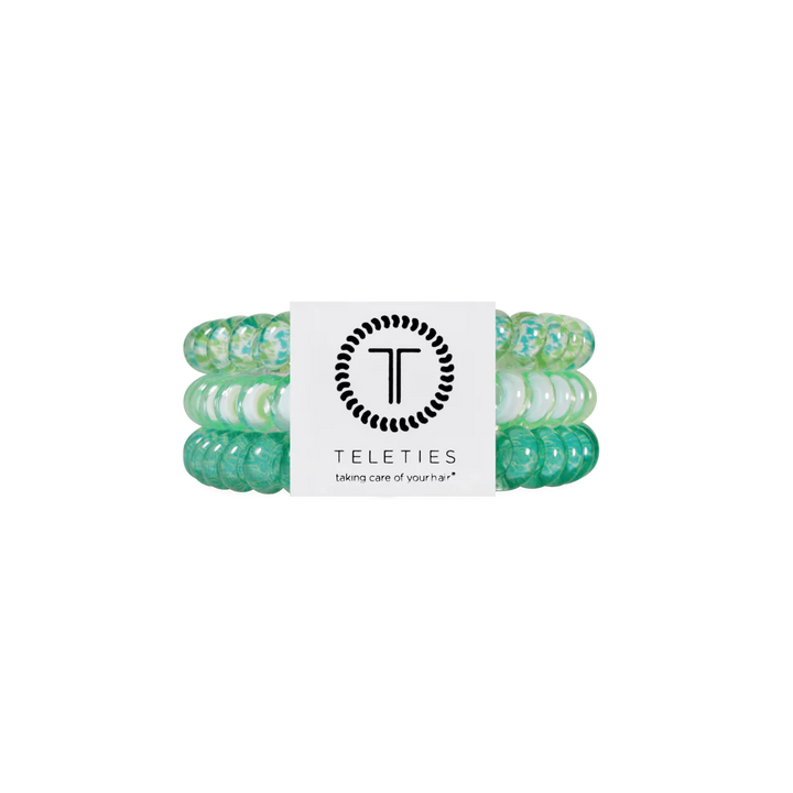 Three green and white TELETIES hair ties, secured by a branded label. Available in small, medium, and large sizes.