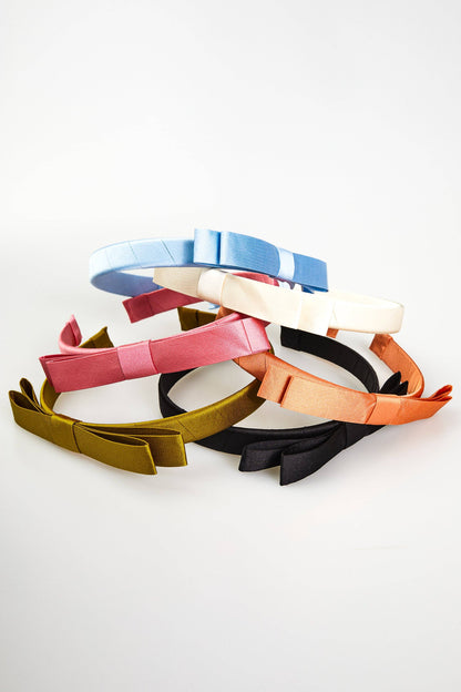 Sloane Mini Bow Headbands in blue, cream, pink, gold, and black satin. Available in one size. Set of five.