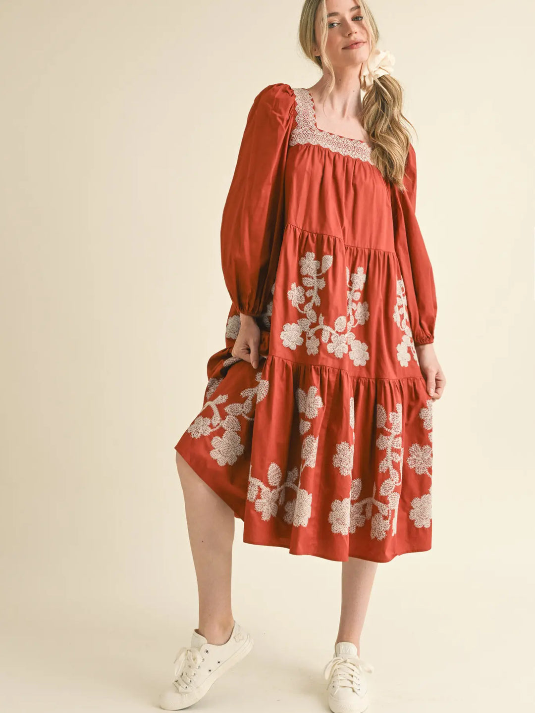 Rust Amber floral embroidered tiered midi dress with square neckline, long sleeves, and white floral embroidery. Available in all sizes.