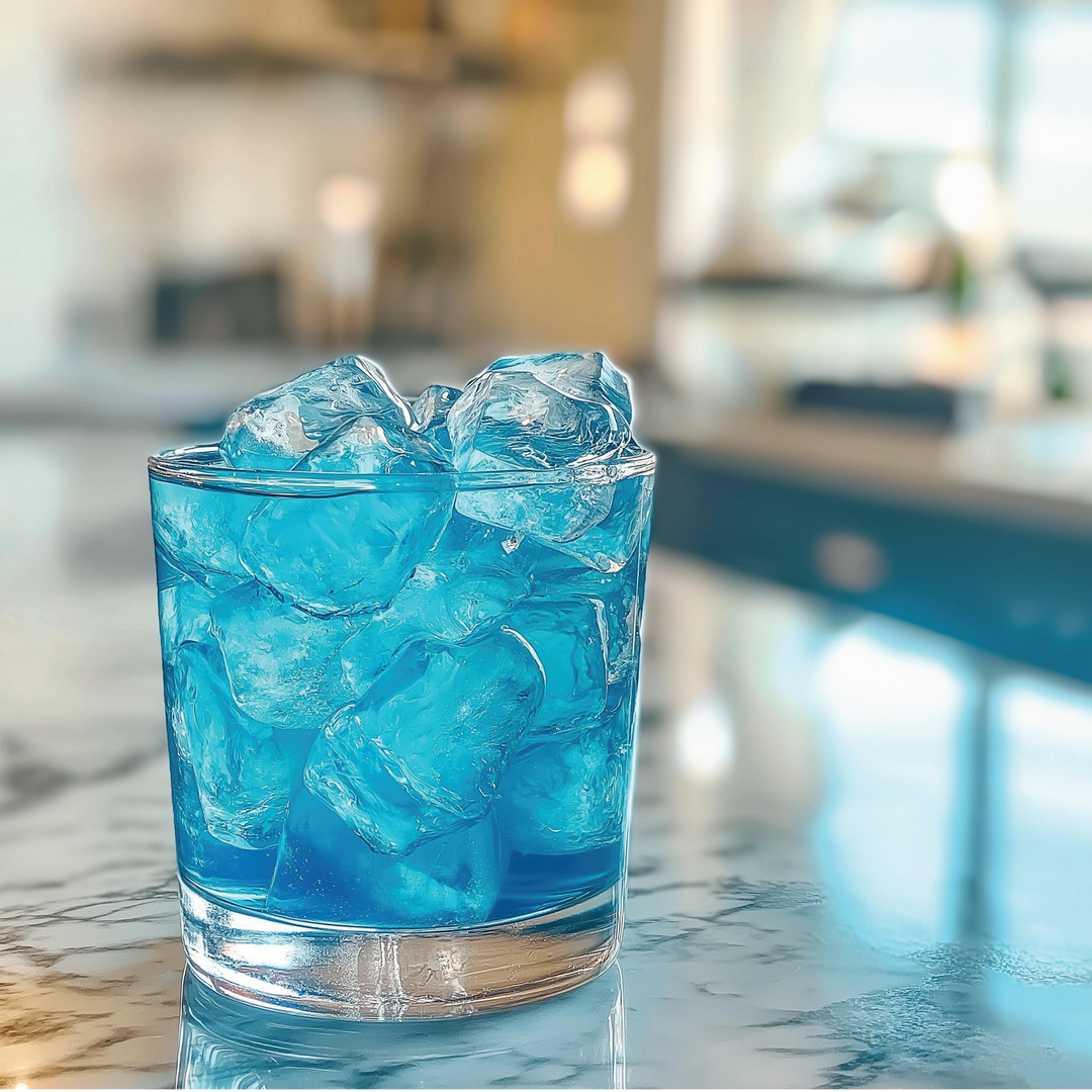 Clear glass with blue liquid and ice cubes from Sugar Free Sour Genie™ Syrup; available in 250mL and 500mL sizes.