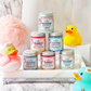 Seven colorful jars of Unicorn Dreams Whipped Bath Soap | Shave Cream mini 3.2oz stacked on a white tray.