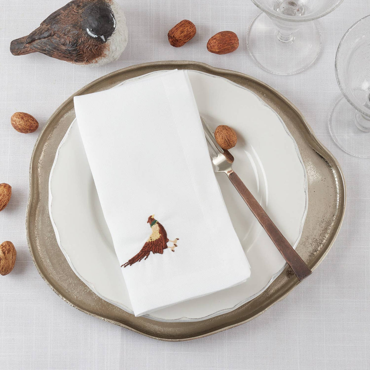 White 20″ Embroidered Pheasant Dinner Napkin displayed on a plate; available in 20″ size.
