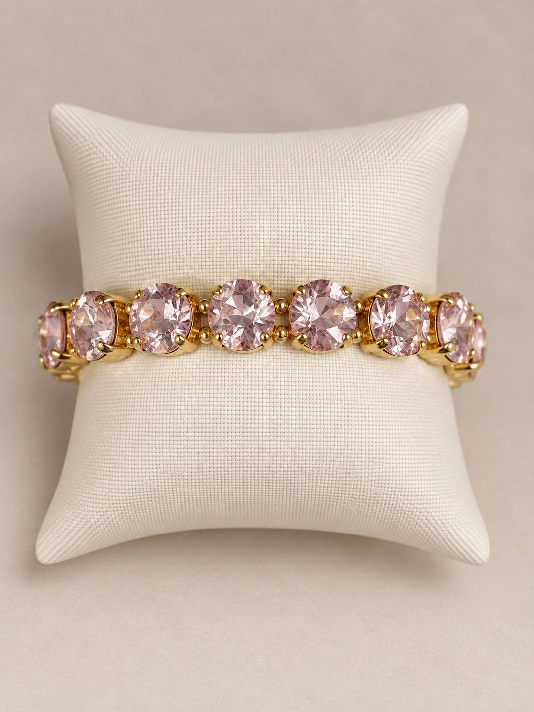 Gemmies Stretch Bracelet with round, light pink stones in a gold-tone setting.