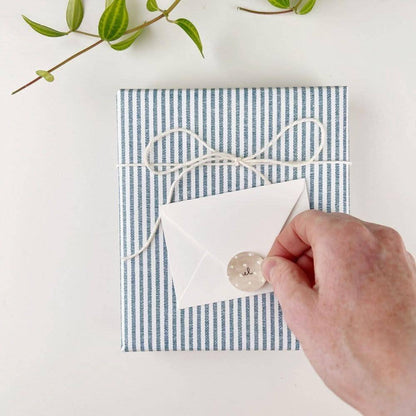 A hand holds a sealed white envelope, sized for Hobnail bouquet mini notecards or gift cards.