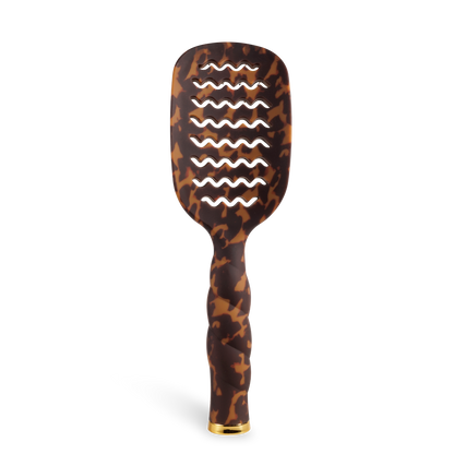 The Vented Hair Brush | Tortoise has a tortoiseshell-patterned, wave-shaped design, a quick-heating aluminum plate, and a gold cap at the handle’s base. Available in multiple sizes.