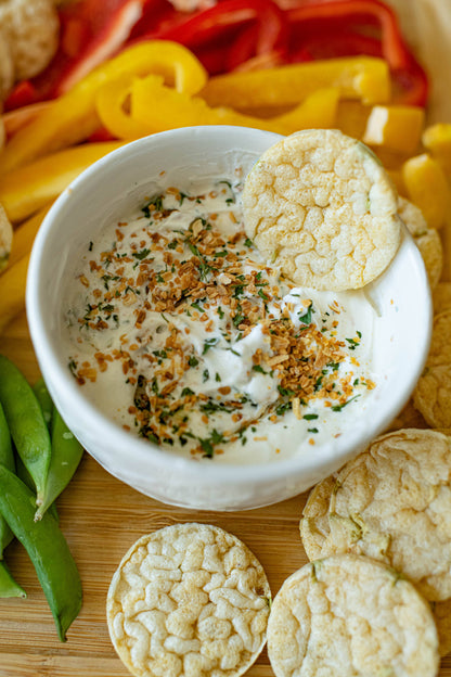 Roasted Garlic Dip Mix in a bowl, topped with herbs and crispy bits. Available in 4 oz, 8 oz, and 16 oz sizes.