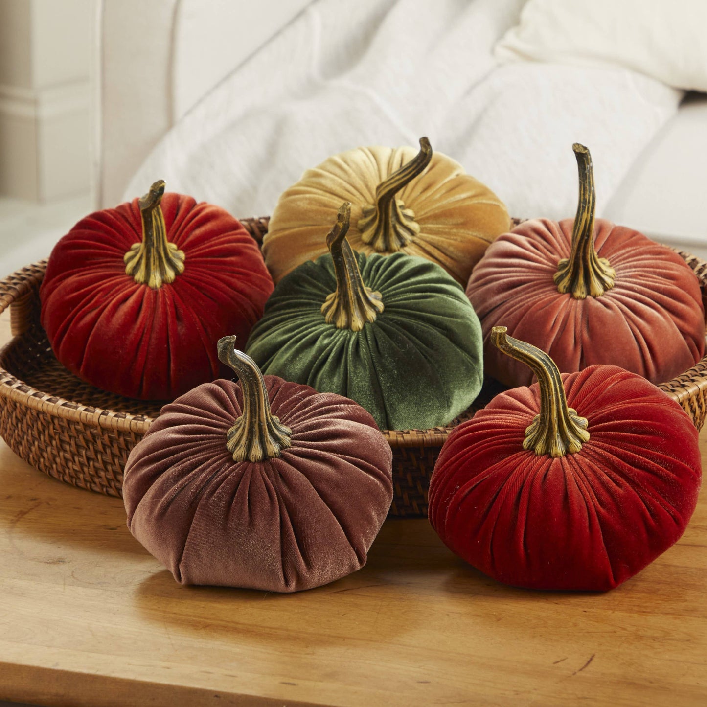 Set of six large velvet pumpkins, including pink, arranged in a wicker basket; available in large size.