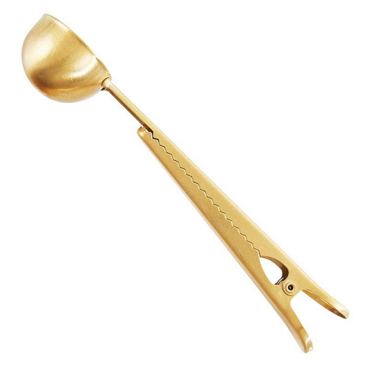 Gold stainless steel coffee clip and scoop with long handle, serrated edge, built-in bag clip. Size options not specified.
