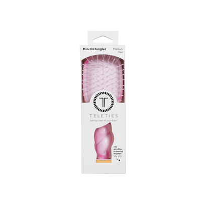 Pink Mini Detangler Brush in medium size, visible through a clear window in white TELETIES packaging with branding and brief product details.