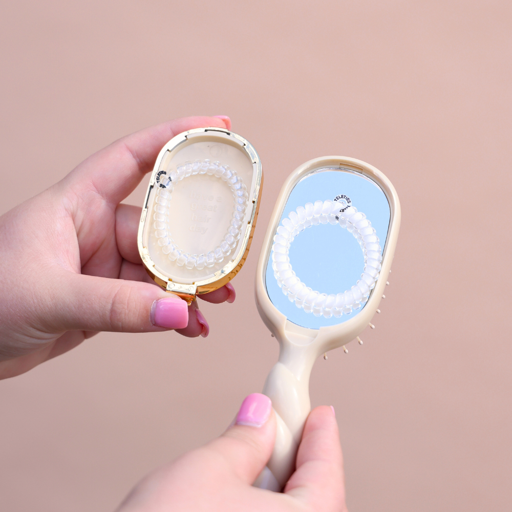 Tan Mini Detangler Brush for Medium Hair with mirror and case, featuring a white spiral hair tie. Available in mini size.
