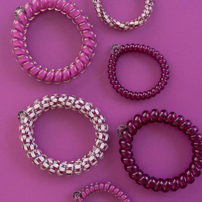 Six Merlot after Midnight Small Hair Ties in pink, purple, and two-tone designs; no-crease styling. Available in small size.