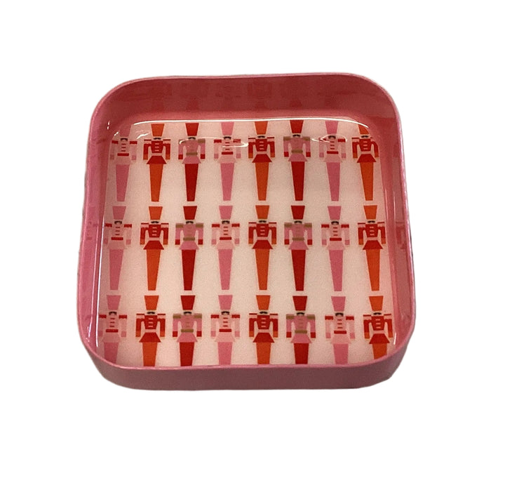 Square pink Jingle Pop Dice Tray featuring a repeating nutcracker pattern in red and pink.