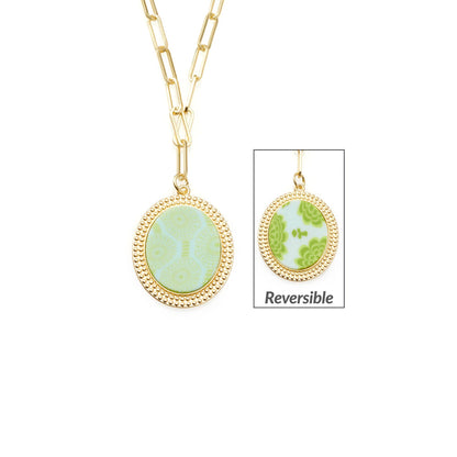 **Seaside Green Reversible Link Medallion Necklace**

- Oval pendant with reversible design
- Front: Seaside Green pattern with circular motifs
- Reverse: Abstract shapes in Maui Blue
- Sizes available: One size

Features a small inset image to highlight the reversible functionality, offering versatile style options.