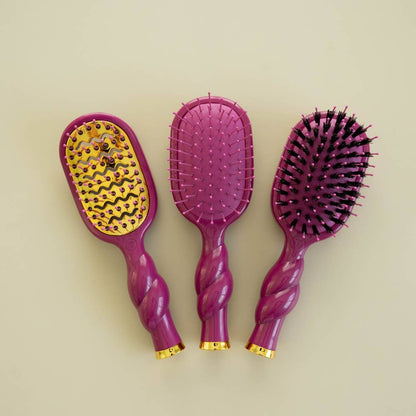 Set of three Mini Boar Bristle Hair Brushes - Mulberry, each with a different bristle style: metal, plastic, and black-tipped boar bristles. Available in travel size.