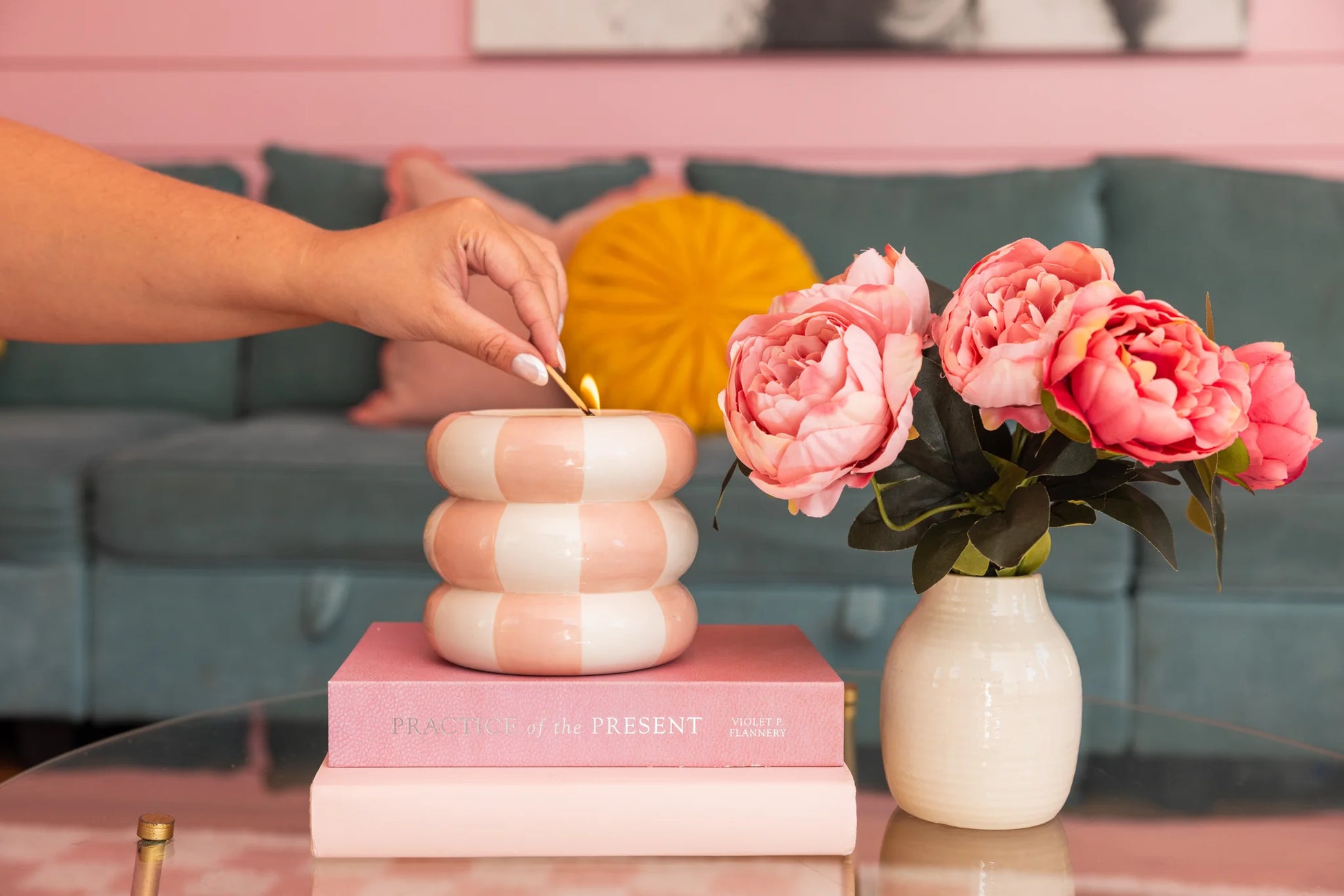Sweet Grace Collection Candle #074 with soy-blend wax; available in multiple sizes. A hand lights the candle on glass table.