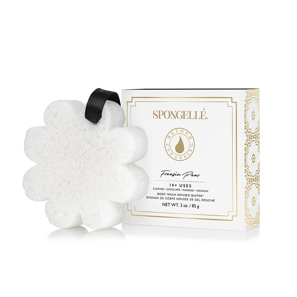 White, flower-shaped body sponge with black ribbon; gold-accented packaging. Available sizes not specified.