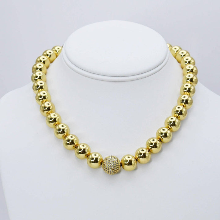 The Golden Pixie Necklace: 16-inch gold chain with large shiny beads and a central crystal-encrusted bead. Available in 16-inch size.