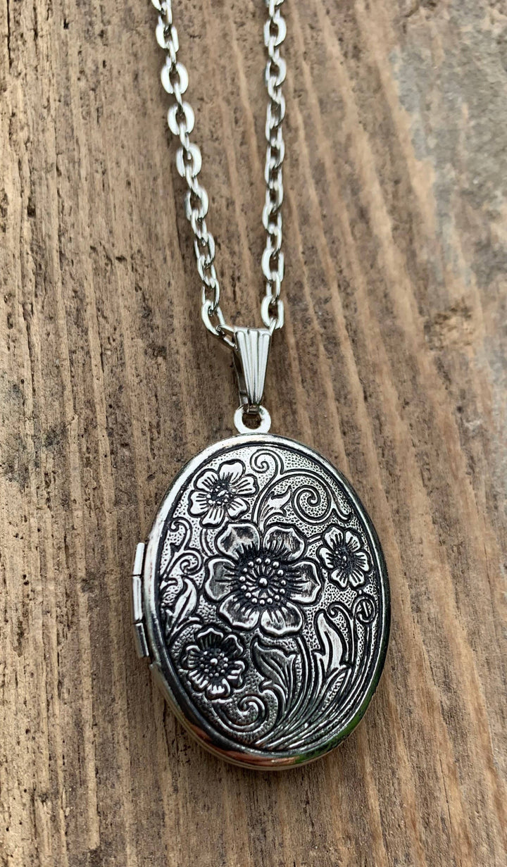 Antiqued silver locket with solid gardenia perfume, intricate floral engraving. Available in small and medium sizes.