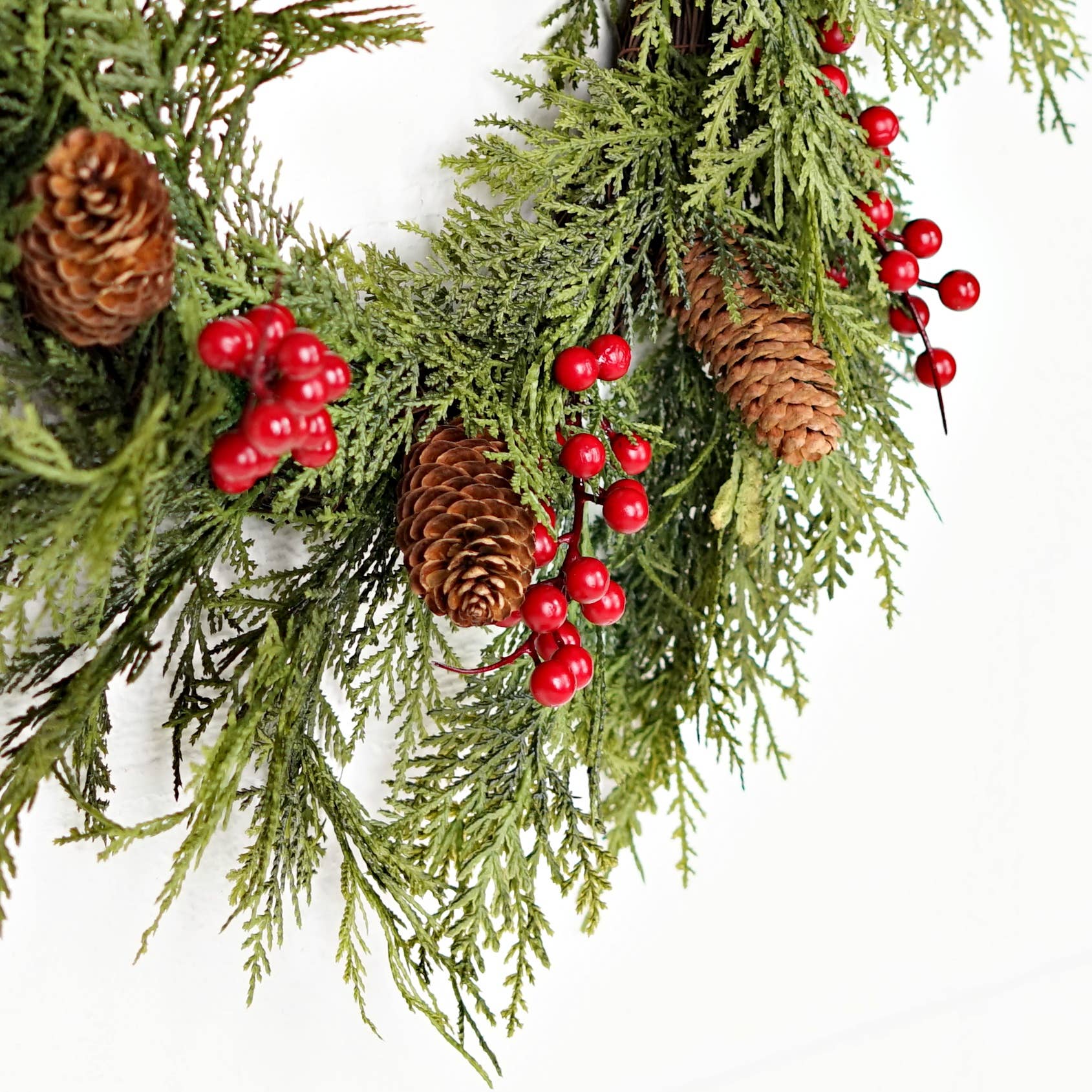 510050-22in Twig Wreath with mix cedar, green pine branches, brown pinecones, and red berries; available in 22 inches.