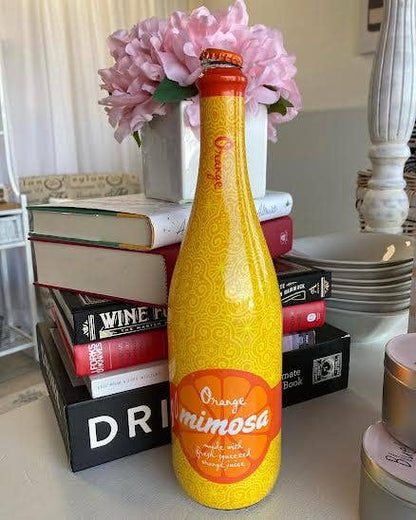 Bottle of orange mimosa available in multiple sizes. Sparkling wine and orange juice blend.