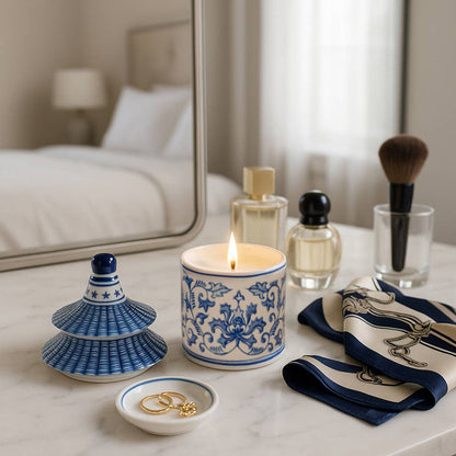 Blue Ceramic Plumeria Chinoiserie Pagoda Candle burning on marble vanity; available in 9 oz size.