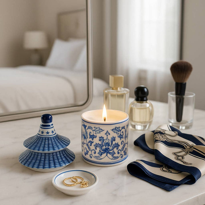 Blue Ceramic Plumeria Chinoiserie Pagoda Candle burning on marble vanity; available in 9 oz size.
