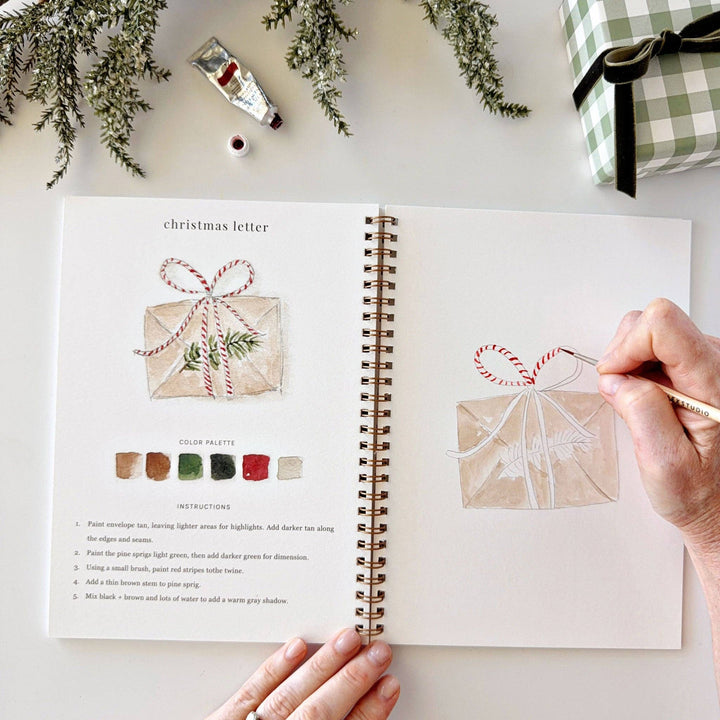 Classic Christmas watercolor workbook featuring step-by-step instructions for painting a red and white striped bow on a gift and decorating a Christmas envelope.