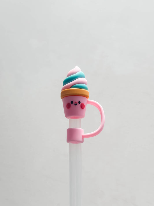 Silicone straw cover shaped like a smiling ice cream cone with pink cheeks and blue, white, and pink swirl. Available in standard size.