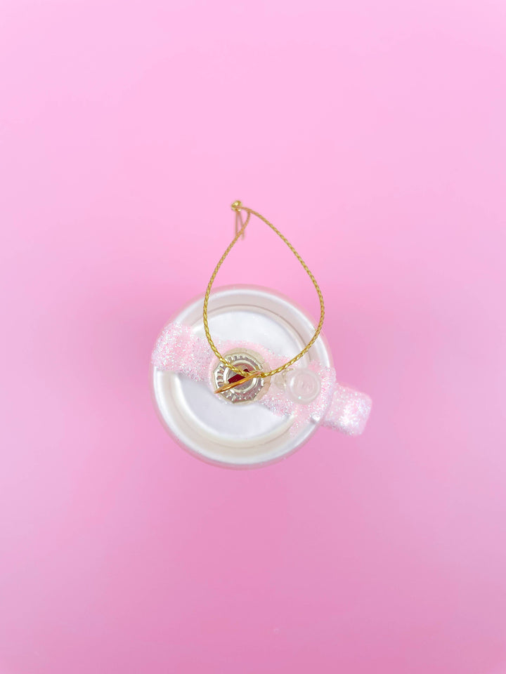 Pink glittered tumbler Christmas ornament with a white base, pink glitter band, and gold hanging string.