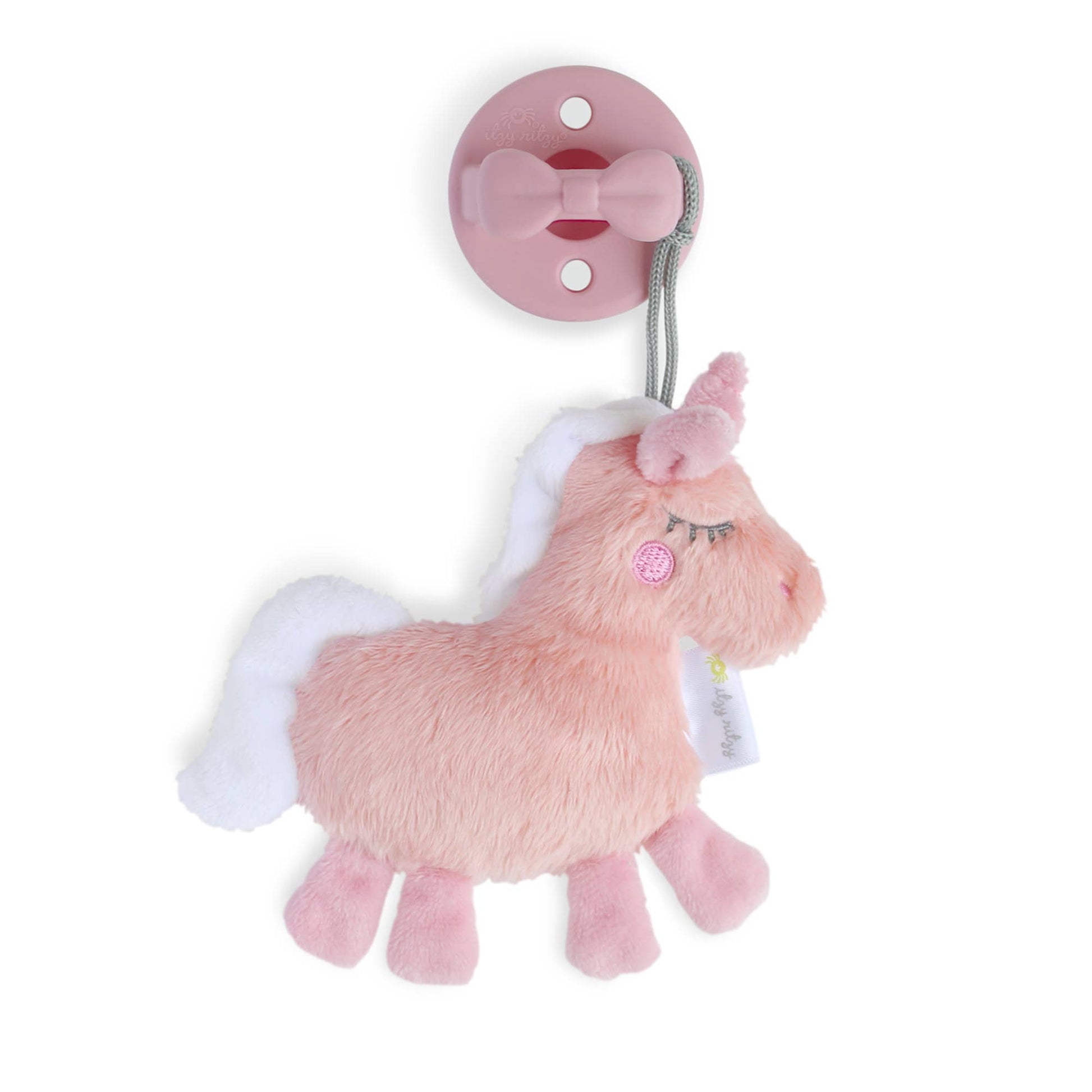 A pink plush Dino pacifier lovey with a pastel pink Sweetie Soother attached to a grey strap, isolated on a white background. The Dino has white wings and a sleepy expression.