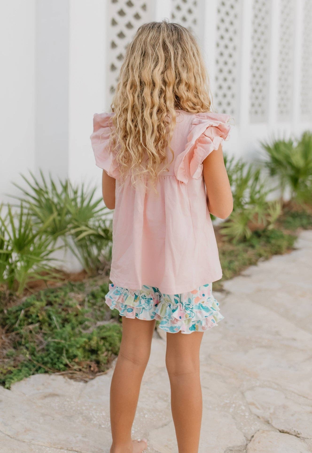 Girls Pastel Floral Ruffle Short Set; available in sizes 2T-10Y. Features pastel florals and ruffled accents.