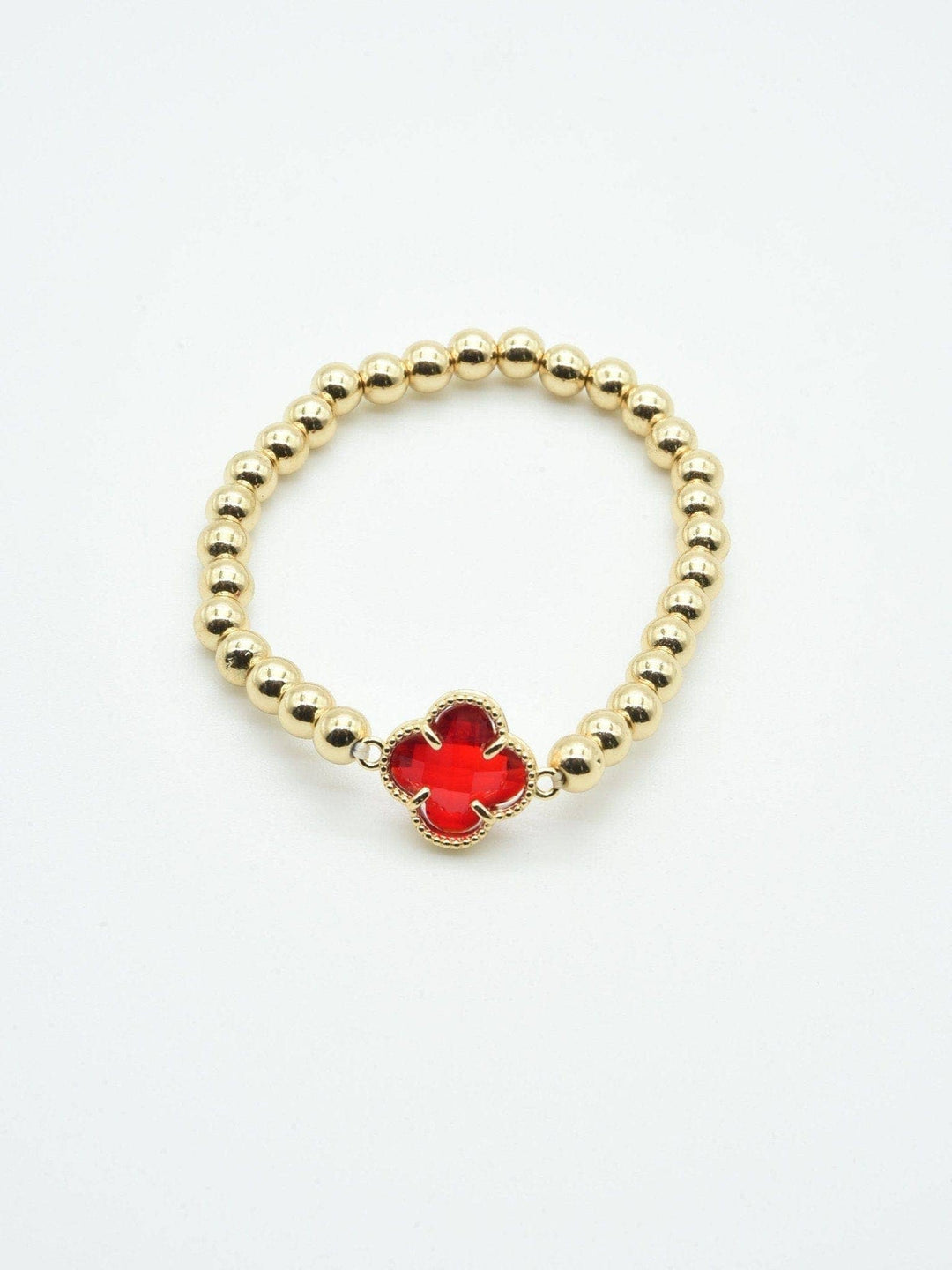 Gold beaded bracelet with a red crystal clover charm at the center. Available in multiple sizes.