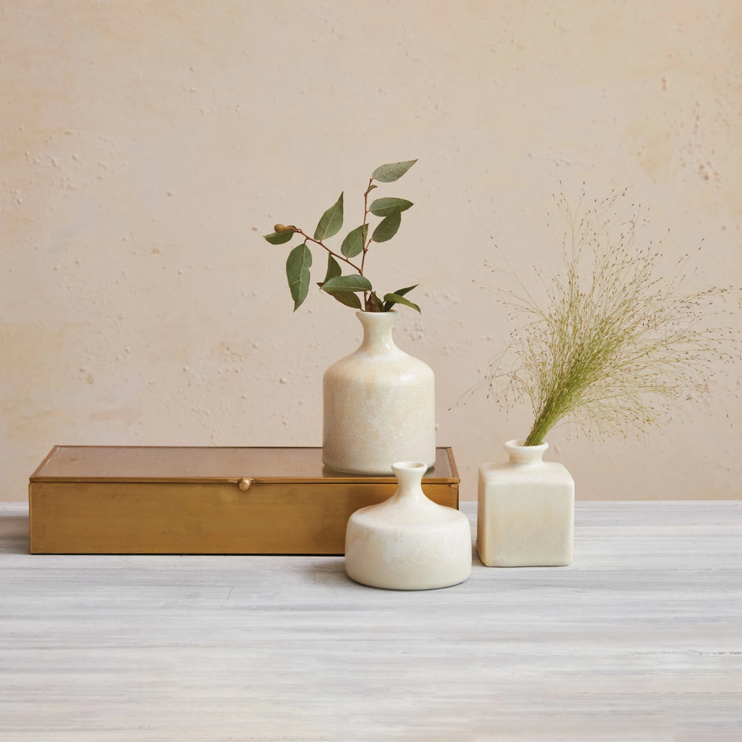 Set of three small, cream-colored stoneware vases in assorted shapes; available in sizes 4", 5", and 6".
