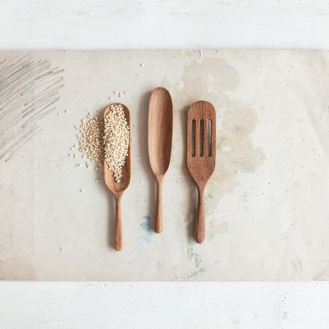 The 7"L Carved Doussie Wood Spoon, Natural, features a smooth wood finish, perfect for adding elegance to your kitchen. Size: 7 inches long.