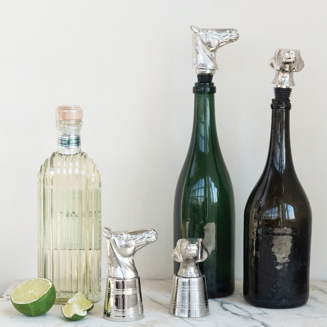 Decorative liquor bottles with Cast Aluminum Animal Head Bottle Stoppers featuring horse and dog designs, nickel finish. Available sizes: One size fits most standard bottles.