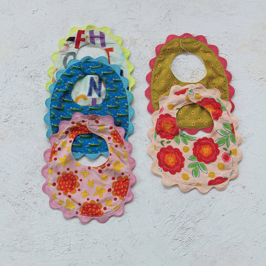 Set of six cotton baby bibs with terry backs, scalloped edges, assorted patterns. Available sizes: S, M, L.