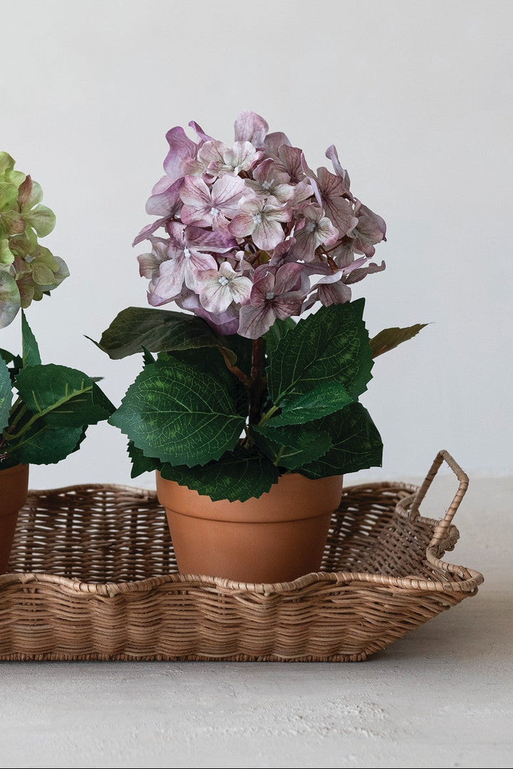 Faux hydrangea in a terracotta-style plastic pot with light purple, lifelike petals; available in 2 colors.